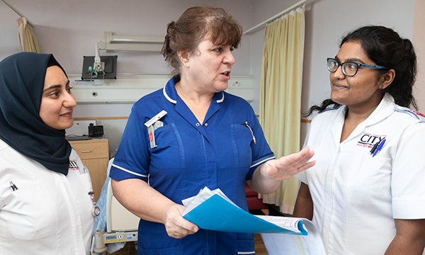 Picture shows two nursing students with a nurse. In its new report, the RCN sets out two different visions for funding nursing education