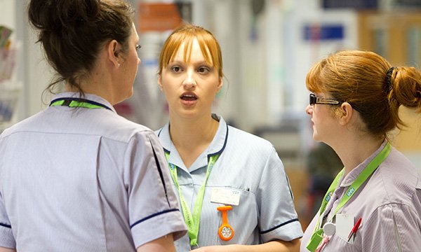 Picture shows nurses in conversation on an NHS hospital ward