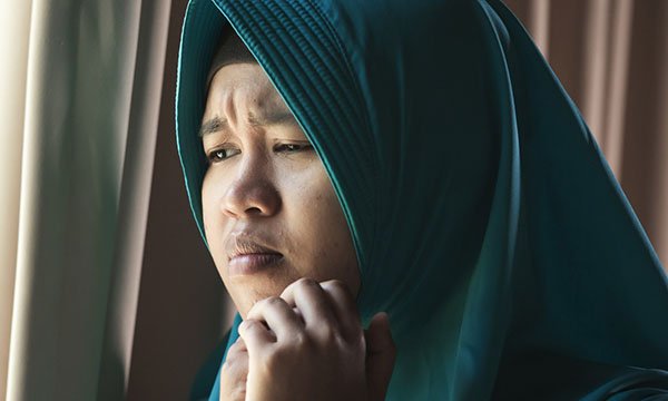 Picture shows a young woman wearing a hijab looking worried. A study shows women from ethnic minority backgrounds living in England are more likely to be embarrassed to go to their GP with potential cancer symptoms than white women
