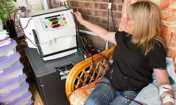 woman uses home dialysis machine