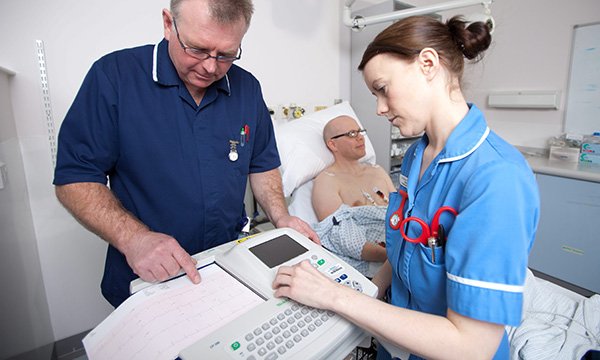 Nurses look at an ECG read-out