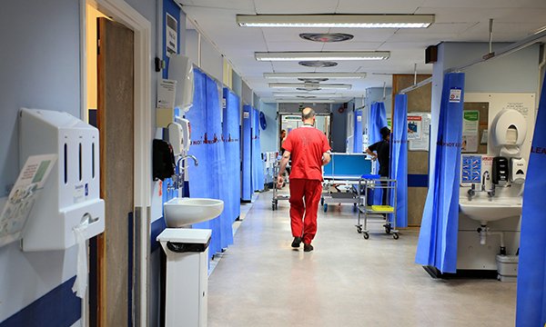 Nurse walking down a hospital ward corridor
