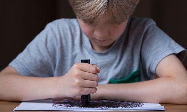 Picture shows a boy drawing as part of therapy. School nurses, health visitors, and general practice nurses are often in a position to identify the damage due to trauma from adverse childhood experiences and the effect on children’s mental health.
