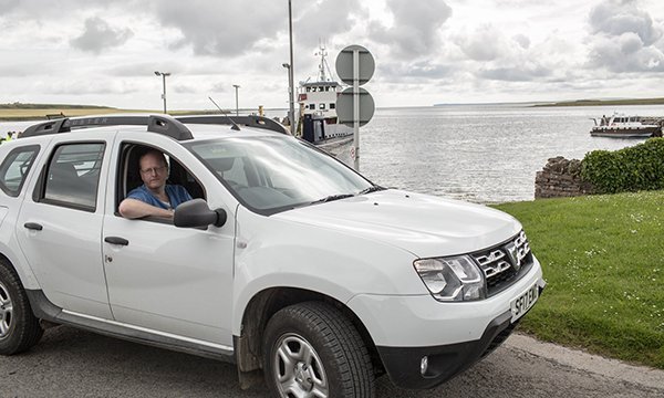 Picture shows Ian Hall, an advanced nurse practitioner at NHS Orkney, in his car at an island harbour. Regional academies for advanced care practitioner roles in Scotland are striving to improve consistency. Picture: QNIS