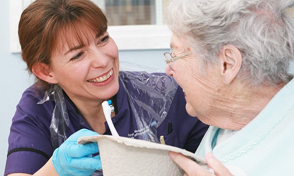 A nurse helps an elderly lady clean her teeth. Picture: Neil O'Connor
