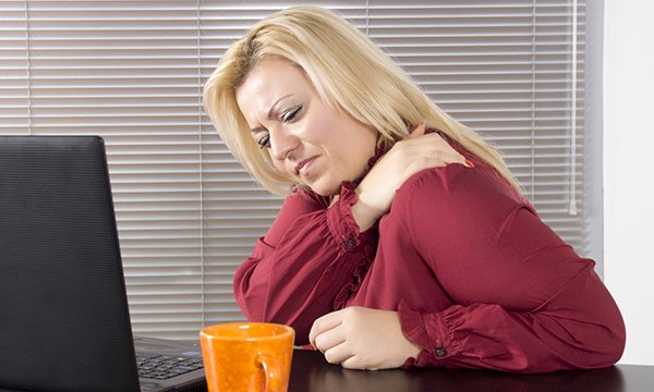 Picture shows a woman holding her shoulder to ease pain. The article stresses the need to raise awareness about coronary heart disease and heart attack, including gradual onset myocardial infarction, so that people know what symptoms to look out for.