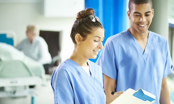 two nurses confer on a ward 