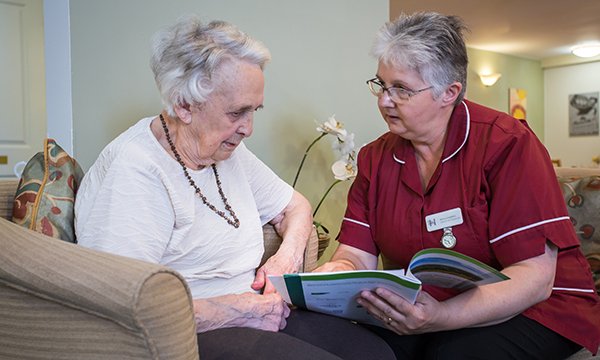 Picture shows a care home supervisor talking to a resident. Healthcare professionals can help meet the needs of older people approaching the end of life by asking the right questions.