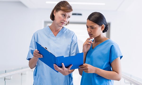 Picture shows two women in scrubs, the older one frowning at the younger one, who is looking at a folder. Being on the receiving end of incivility is always unpleasant but in a healthcare setting it can be dangerous.
