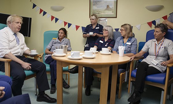 Boris Johnson sits around a table talking to nurses at West Cornwall Hospital