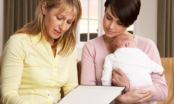 Picture shows a health visitor with a mother and baby. Health visitor numbers in England are the lowest on record, according to an analysis of NHS data by the Labour Party.