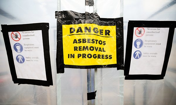 Yellow safety signs reads: 'Danger – Asbestos removal in progress