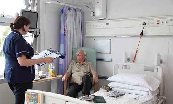 Photo of nurse and older patient as an illustration of bed-blocking