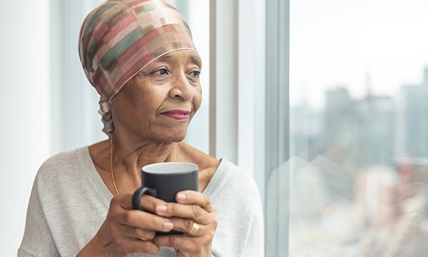 Picture of a lonely older woman looking out of a window