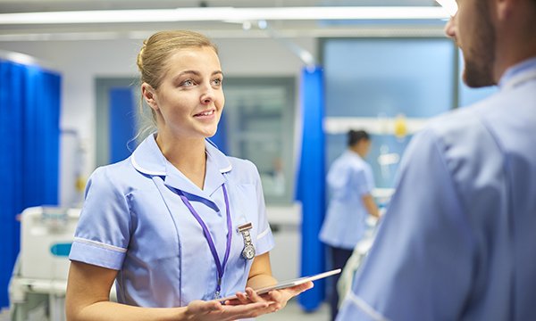 nursing student talks to colleague on a ward
