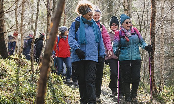Picture shows a group of hikers going through a wood. Evidence shows physical exercise has a positive effect on patients before, during and after treatment.