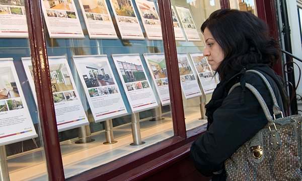 Woman looking at an estate agent's window