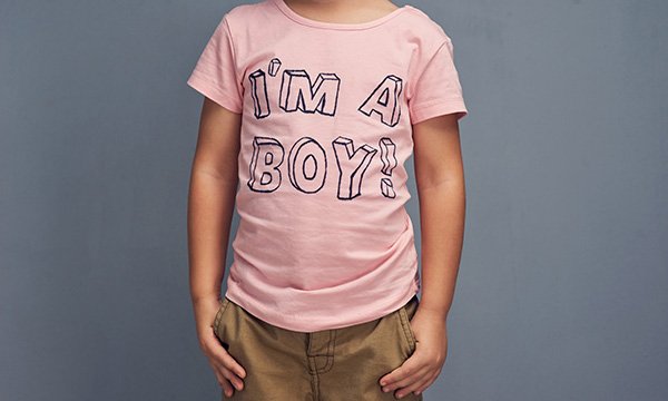 Picture shows a child wearing a pink T-shirt with ‘I’m a boy!’ printed on it