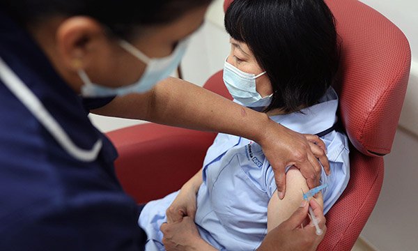 nursing staff member receives coronavirus vaccine as RCN survey points to gap in coverage across nurse workforce