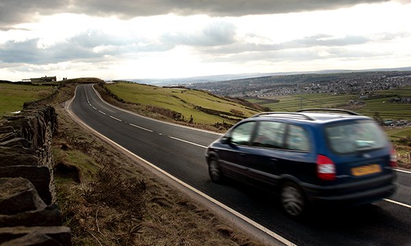 Picture shows a car being driven on an open road in a rural area