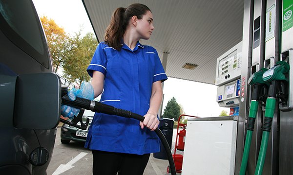 Picture of a nurse filling her car at a petrol pump