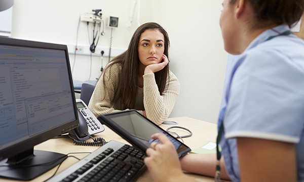 Nurse in GP setting talks to patient