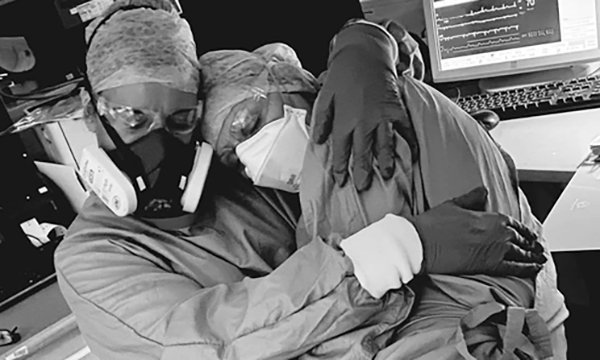 Photo of Jill Kirk and Karen Colbeck-Rowe consoling each other after a gruelling 12-hour shift on a COVID critical care unit
