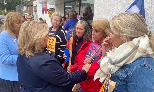 Striking nurses holding strike banners and RCN leader Pat Cullen on picket line in Cardiff