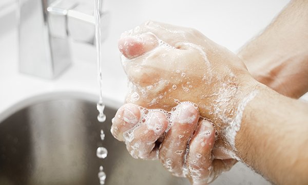 Photo of hands being washed with soap, illustrating news that nurses can use milder soaps to kill many viruses