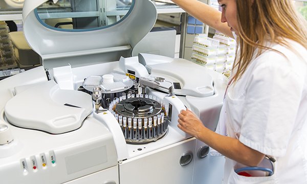 A nurse researcher examining equipment in a laboratory