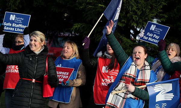 Nurses holding RCN flag and placards picket Ulster Hospital outside Belfast during winter 2022-23 pay strike