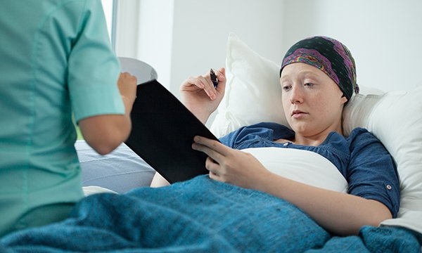 patient signs a form in bed