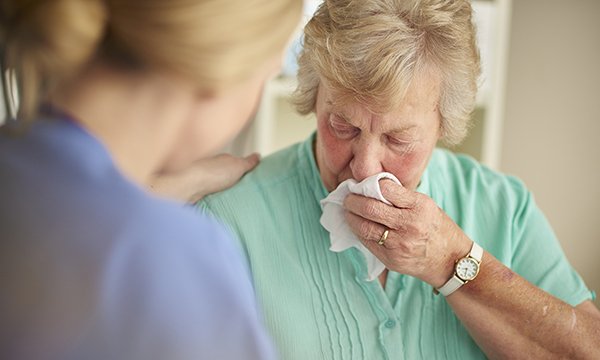 nurse comforts tearful woman