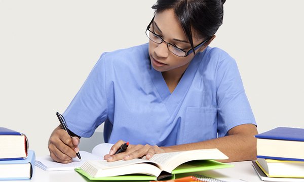 A woman in a nurse's uniform studying