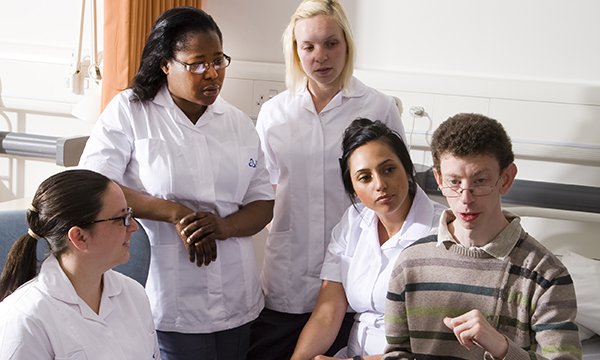 A group of nurses in a room with a young man with an LD