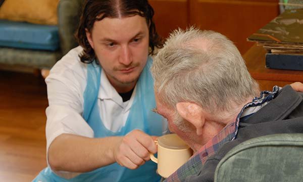 healthcare worker helps man to eat