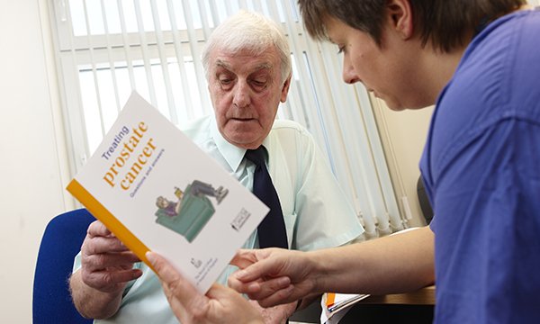 Picture shows an older man being handed a booklet on prostate cancer by a nurse. The prostate cancer specialist nursing workforce could collapse within the next decade unless urgent action is taken, according to researchers.