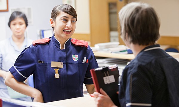 Nurse leader talks to colleague in a ward setting