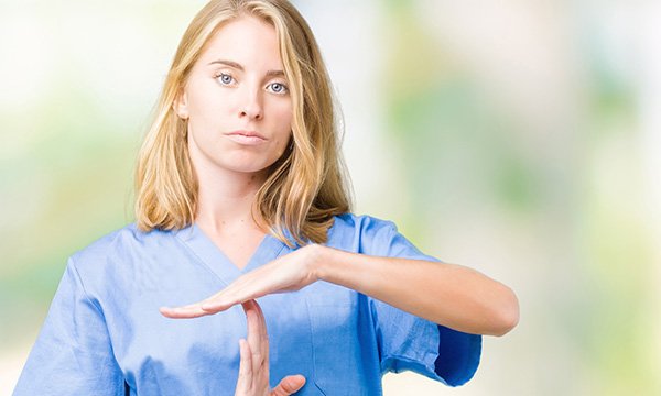 nurse makes the 'time out' sign with her hands 