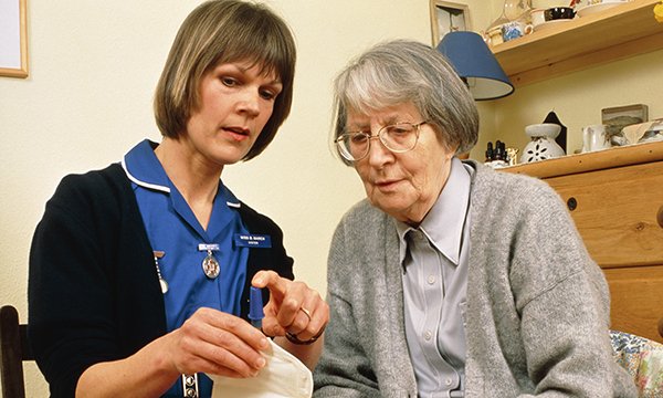 district nurse talking to patient in her own home