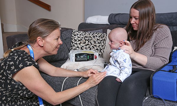 Picture shows RCNi Awards 2019 Child health category winner Joanna Broderick (left) with a mother holding a baby and following the oxygen weaning guideline she developed. 
