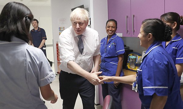 Prime Minister Boris Johnson speaking to nurses during a visit to the East Midlands and East of England Genomic Laboratory Hub at Addenbrooke's Hospital in Cambridge in October 2019, before the government promised to boost NHS nursing numbers by 50,000