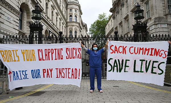 nurse protests outside the gates to Downing Street about pay and PPE