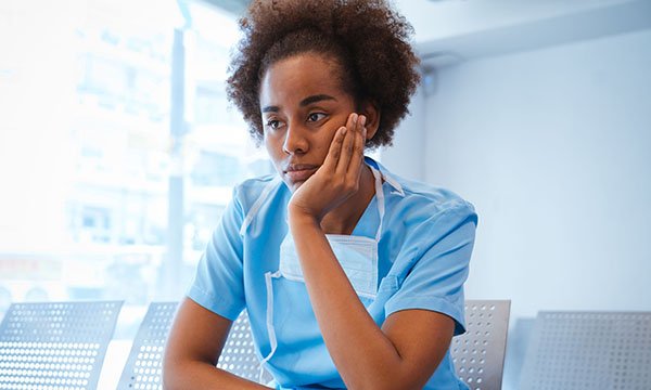 A depressed looking black nurse. Over half of BAME nurses say their experiences over the pandemic led them to consider quitting Picture: iStock