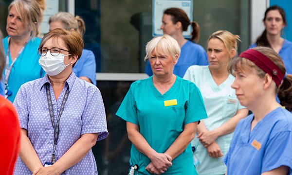 Healthcare staff observe a minute's silence
