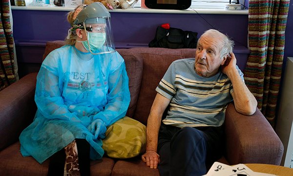 Image of a care home nurse wearing personal protective equipment whilst attending to a resident