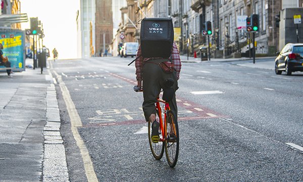 Picture shows a cyclist carrying a rucksack labelled Uber Eats