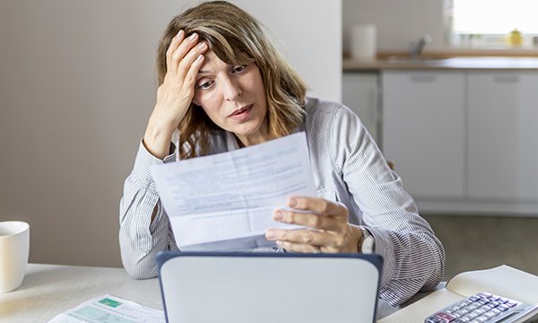 Photo of woman looking concerned about bill, illustrating story about nursing students' financial worries