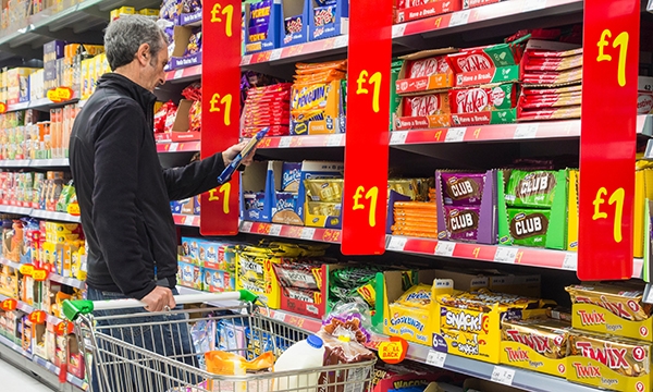 Man in supermarket browsing biscuit section