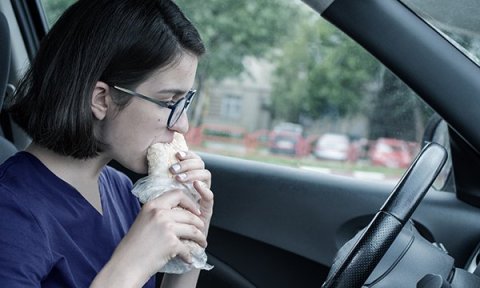 Nurse eating on a break in the car
